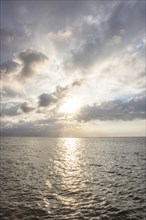 Beautiful seascape in the morning. Tropical sandy beach with breakwater and reflection of the sky