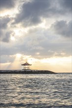Beautiful seascape in the morning. Tropical sandy beach with breakwater and reflection of the sky