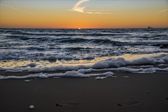 Den Helder, Netherlands. January 2022. Setting sun on the beach of Den Helder, Netherlands.