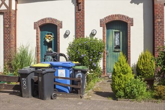 Colourful different dustbins standing in front of a house entrance, Delmenhorst, Lower Saxony,