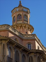 Ornate historic building with a tower and numerous windows under a clear sky, palma de Majorca,