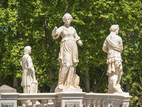 Stone statues in a park against a background of dense green trees, palermo, sicily, mediterranean