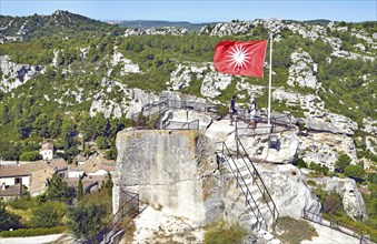 The flag above the mountain ruins and the Alpilles