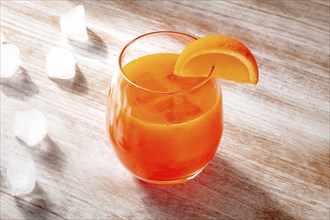 Orange drink on a wooden background, fresh pressed juice with a fruit slice and ice, Food