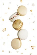 Isolated on white background white, yellow, gold macaron cookies flying, falling in motion or