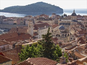 Overview of a city with red tiled roofs, an island in the background and the sea, dubrovnik,