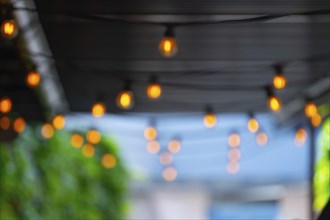 Out of focus image of decorative light bulbs hanging from the roof