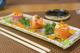 Platter decorated with different flavors of elegant sushi. Selective focus