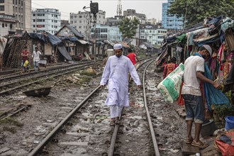 A man balances on the rail of a railway track, Tejgaon Slum Area, Dhaka, Bangladesh, Asia