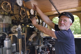 Bernd Roschach, train driver chairman of the Acher Valley Railway Society, standing in a locomotive