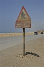 Warning sign warns of sand dunes, near Mirbat, Dhofar Region, Oman, Asia