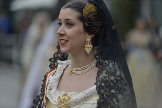 Fallas festival, woman in a traditional costume during the parade in the Plaza de la Virgen de los