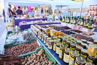 Market stall with honey und nuts and vegetables on a weekle market near Tarragona, Catalonia,