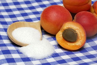 Apricots ( Prunus armeniaca) , Cooking spoon with sugar