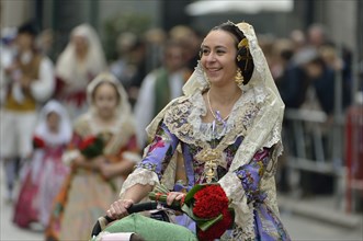 Fallas festival, young woman in a traditional costume during the parade in the Plaza de la Virgen