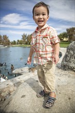 Young chinese and caucasian boy having fun at the park and duck pond