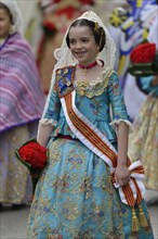 Fallas festival, girl in a traditional costume during the parade in the Plaza de la Virgen de los