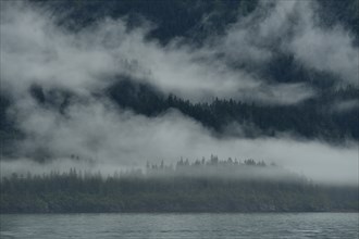 The westerly wind pushes the clouds against the steep slopes of the Chugach Mountains, the moisture