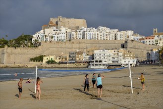 Beach volleyball players on the beach of Peñíscola, in the background the old town, province