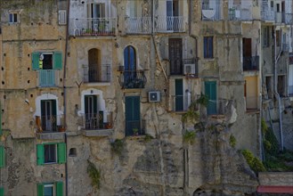 Dilapidated house facade with balconies of the medieval town of Tropea built on rocks of sandstone,