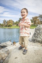 Young chinese and caucasian boy having fun at the park and duck pond