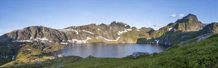 Mountain landscape with lake Krokvatnet, in the back mountain peak Helvetestinden, at sunrise,