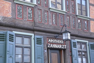 Historic half-timbered house with flowers as wall painting and wood carving with inscription