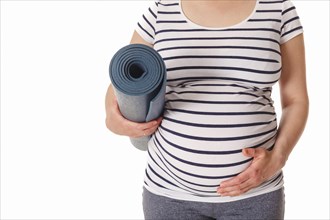 Pregnancy yoga concept, pregnant woman standing with yoga mat close up isolated on white background