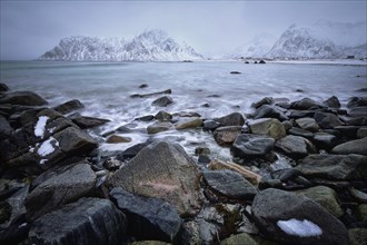 Waves and rocks on coast of Norwegian sea in fjord. Skagsanden beach, Flakstad, Lofoten islands,