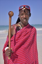 Young Maasai man wearing traditional dress and sunglasses on the beach, Dongwe Beach, Dongwe,