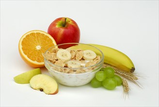 Muesli with milk in shell, apple, banana, orange, grapes, muesli