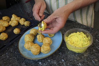 Swabian cuisine, preparing mini cream puffs, filling eclairs with cream cheese, profiterole,