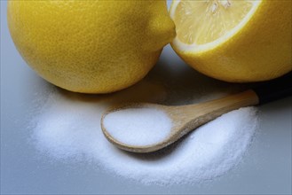 Citric acid in wooden spoon and lemon