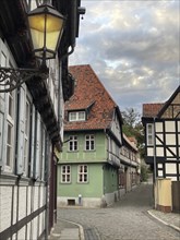 Empty alley with glowing alleyway lamp half-timbered houses in UNESCO World Heritage historic old