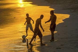 Young men playing football at sandbeach in twilight. Santa Maria. Sal. Cabo Verde. Africa