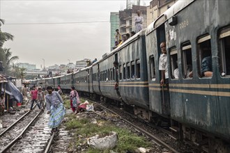 A train passes through an informal settlement built close to a railway line, Tejgaon Slum, Area,