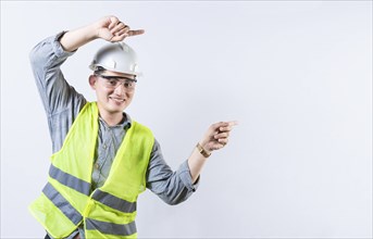 Portrait of smiling engineer pointing aside isolated. Handsome engineer pointing an advertisement