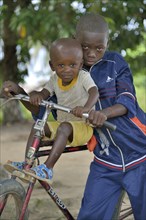 Two children with a bicycle, Nkala, Bandundu Province, Democratic Republic of the Congo