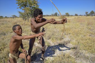 Bushmen of Ju/' Hoansi-San with bow and arrow in traditional hunting, village //Xa/oba, near