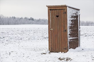 Single wooden toilet house with heart in door in the snow, Freital, Saxony, Germany, Europe