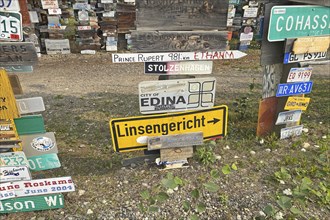 Place and traffic signs in a forest of signs, Linsengericht in Hesse, Watson Lake, Yukon Territory,