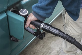 Close up of man pumping diesel fuel into his vehicle at service station