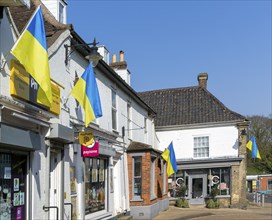 Support for Ukraine, Ukrainian national flags flying outside shops, Saxmundham, Suffolk, England,