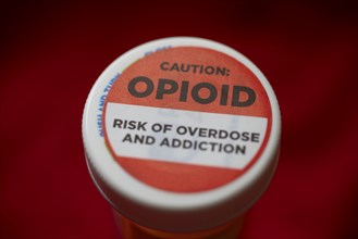 A label on a bottle of hydrocodone-acetamin opioid prescription pills warns against the danger of