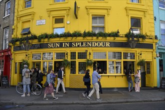 Guests and passers-by outside the Sun pub in Splendour on Portobello Road, London, England, United