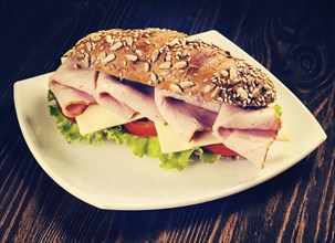 Vintage retro effect filtered hipster style image of ham sandwich with lettuce, cheese, tomato on