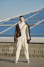 Urban fashion. Young man in loose clothes posing on the street