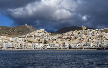 View of the town of Ermoupoli with pastel-coloured houses and sea, on the hill Anastasi Church or