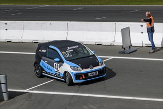 Racing car for series VW up! GTI Cup with driver Leon Arndt is marshalled into Parc Fermé by track