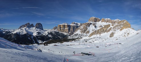 Panorama of a ski resort piste with people skiing in Dolomites in Italy. Ski area Belvedere.